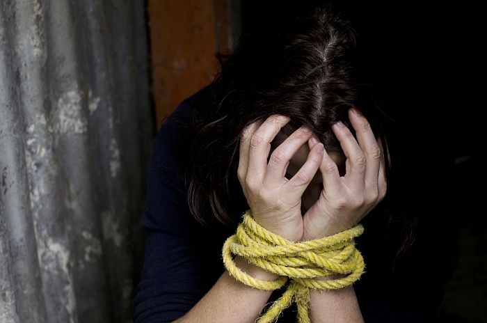 Missing kidnapped, abused, hostage, victim woman with hands tied up with rope in emotional stress and pain, afraid, restricted, trapped, struggle, terrified, threaten, locked in a cage cell.