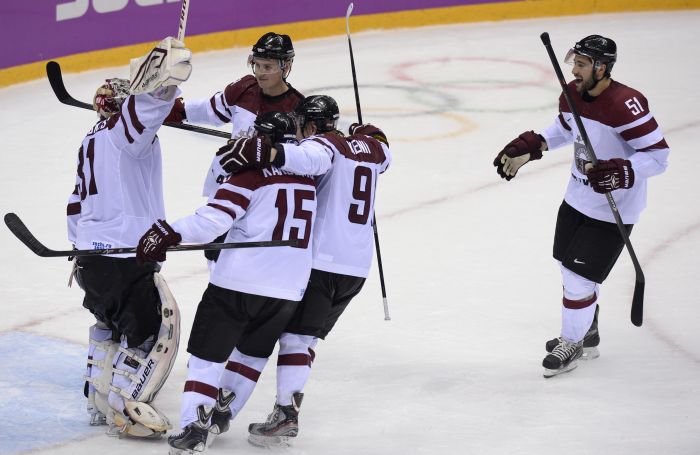 Latvian players celebrate a 3-1 victory during the Men’s Ice Hockey Play-offs Switzerland vs Latvia at the Bolshoy Ice Dome during the Sochi Winter Olympics on February 18, 2014. AFP PHOTO / ALEXANDER NEMENOV