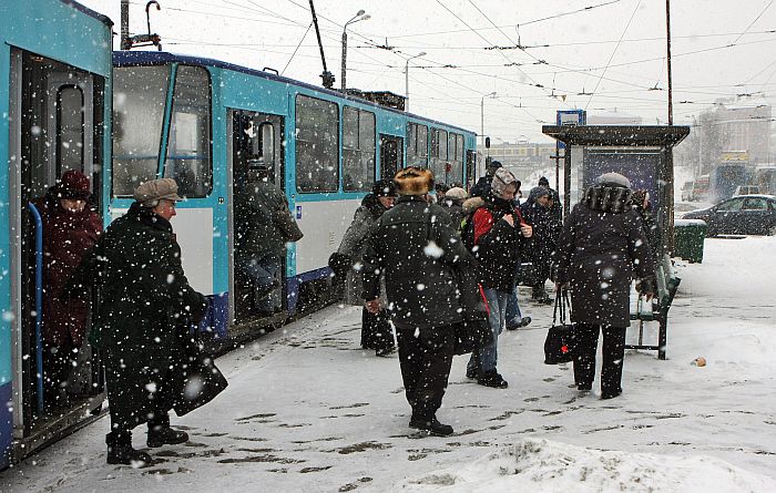 Cilvēki tramvaja pieturā pie Rīgas Centrāltirgus sniegputeņa laikā.