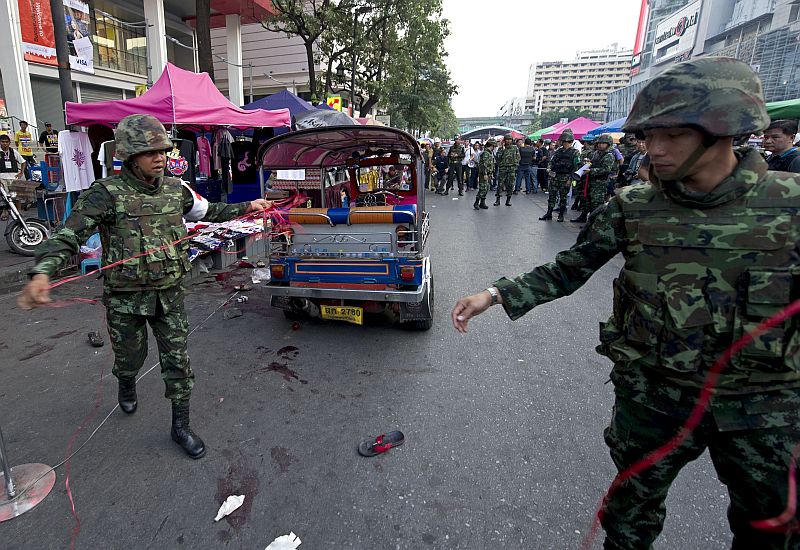Thai soldiers inspect the site of bomb blast near an anti-government rally in Bangkok on Fenruary 23, 2014. At least sixteen people were injured in a blast in a popular Bangkok shopping district on Fenruary 23, health officials said, further amplifying tensions a day after gunmen opened fire on an anti-government rally in eastern Thailand, killing a five-year-old girl. AFP PHOTO / PORNCHAI KITTIWONGSAKUL
