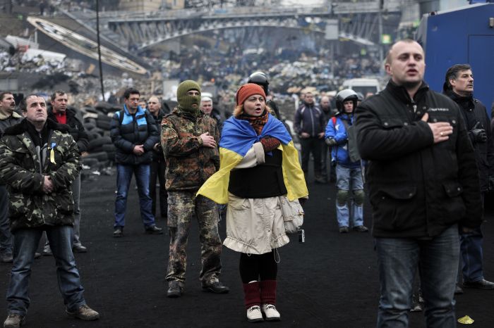 Anti-government protesters sing the Ukrainian national anthem at the Independence square in central Kiev on February 22, 2014. Ukraine’s leader and opposition on Friday signed a deal to end the splintered country’s worst crisis since independence after three days of carnage left nearly 100 protesters dead. President Viktor Yanukovych’s dramatic decision to hold early elections and form a new unity government was met with caution by the tens of thousands gathered on central Kiev’s main square for a protest that began exactly three months earlier. AFP PHOTO/ LOUISA GOULIAMAKI