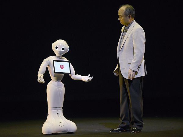 SoftBank CEO and chairman Masayoshi Son interacts with humanoid robot ‘Pepper’ during its unveiling at a press event held near Tokyo in Urayasu, Chiba prefecture, Japan, 05 June 2014. Capable of interacting through emotions and body langage, Pepper is the described by the developers as the ‘World’s first personal robot that reads emotions.’ It will be on sale from February 2015 for a base price of 198,000 JPY (1,930 USD). The robot was developed in collaboration with French company Aldebaran Robotics.