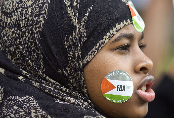 A pro-Palestinian demonstrator has a “Free Palestine” sticker on her cheek as she joins a protest against the conflict in Gaza outside Downing Street in London on August 23, 2014. Israel kept up the pressure on Hamas in Gaza on August 23, carrying out multiple air strikes that killed six Palestinians, five of them from the same family, as Egypt prepared to convene new truce talks. AFP PHOTO / JUSTIN TALLIS