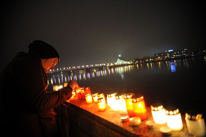 Cilvēki noliek svecītes Lāčplēša dienā pie Daugavas 11.novembra krastmalā.