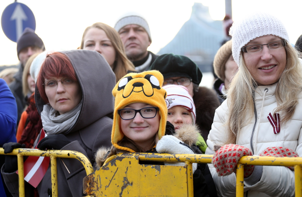Cilvēki vēro Latvijas Republikas proklamēšanas 96.gadadienai veltīto Nacionālo bruņoto spēku parādi 11.novembra krastmalā.
