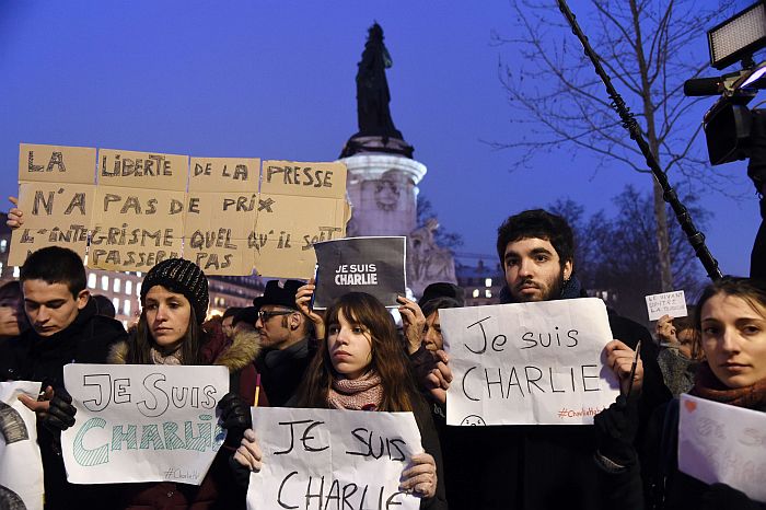 A man holds a placard reading : “Freedom of the press is priceless, fundamentalism, of any kind, will not pass” as others hold up placards reading in French, “I am Charlie” during a gathering at the Place de la Republique (Republic square) in Paris, on January 7, 2015, following an attack by unknown gunmen on the offices of the satirical weekly, Charlie Hebdo. France’s Muslim leadership sharply condemned the shooting at the Paris satirical weekly that left at least 12 people dead as a “barbaric” attack and an assault on press freedom and democracy. AFP PHOTO / DOMINIQUE FAGET