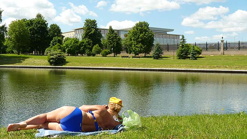 Atpūta Svisločas upes krastā. Tālumā – jaunā Neatkarības pils.