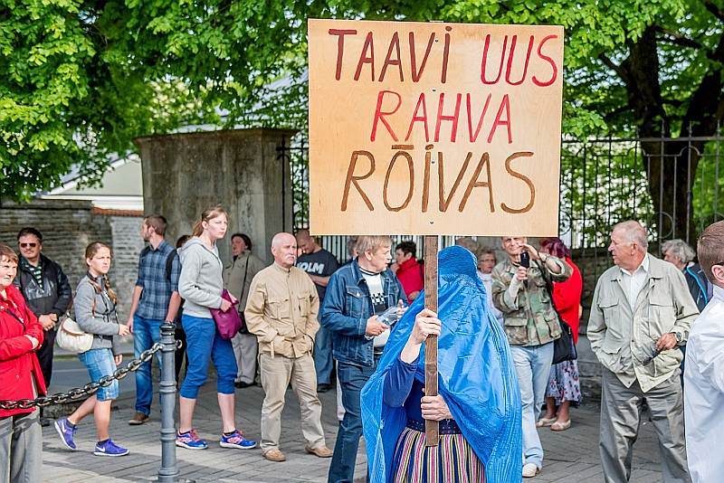 Protestu pret valdības plāniem “brīvprātīgi” uzņemt afrikāņu bēgļus pagājšnedēļ rīkoja Igaunijas Konservatīvā tautas partija. Uzraksts uz plakāta: “Tāvi jaunais tautas tērps”. (Izmantota vārdu spēle ar Igaunijas premjerministra Tāvi Reivasa uzvārdu, jo “rõivas” igauņu valodā nozīmē “apģērbs, kostīms”.)