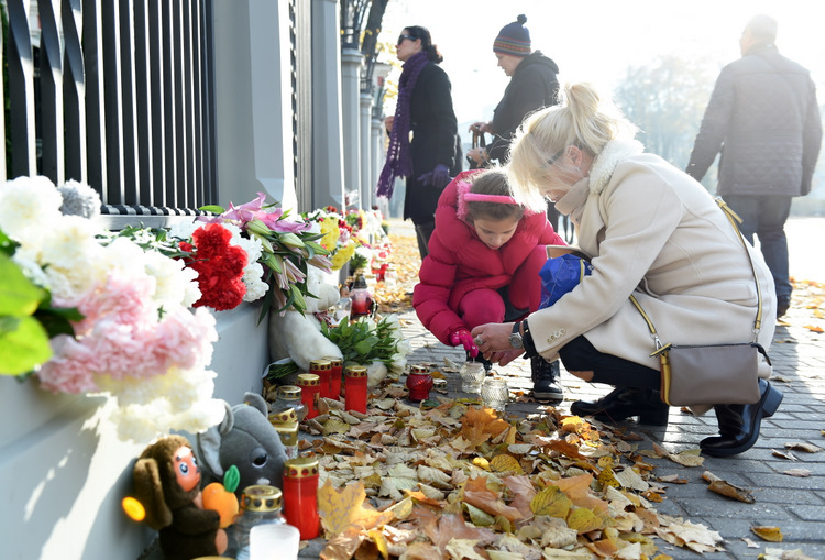 Cilvēki noliek ziedus pie Krievijas vēstniecības ēkas Rīgā traģiskajā aviokatastrofā Ēģiptē bojāgājušo piemiņai.