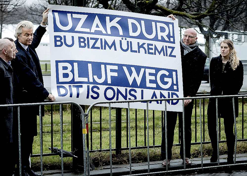 Nīderlandes galēji labējās Brīvības partijas līderis Gērts Vilderss (no kreisās) pie Turcijas vēstniecības Hāgā protestē pret Turcijas ārlietu ministra Mevlita Čavušolu plānoto uzstāšanos mītiņā, lai aģitētu par prezidenta pilnvaru paplašināšanu Turcijā gaidāmajā referendumā. Vildersa plakāts vēsta: “Turieties pa gabalu! Šī ir mūsu valsts.”