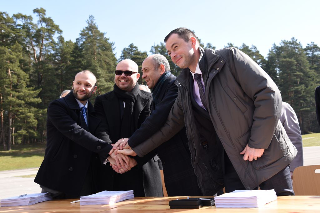 AS “LNK Industries” valdes locekļi Dāvids Lipkins (no kreisās) un Jevgēņijs Locevs, Rīgas domes Īpašuma departamenta direktors Oļegs Burovs un SIA “RERE Būve” valdes priekšsēdētājs Valdis Koks sarokojas pēc Rīgas domes un pilnsabiedrības “LNK, RERE” līguma par Mežaparka Lielās estrādes rekonstrukciju parakstīšanas uz estrādes skatuves.