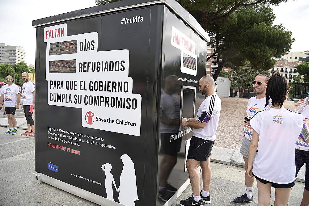 Vīrietis 25. jūnijā paraksta petīciju pie organizācijas “Glābiet bērnus” elektroniskās letes Kolonnu laukumā Madridē, kurā atgādina Spānijas valdībai to patvēruma meklētāju skaitu, kuriem nav izdevies sasniegt Spānijas krastus.