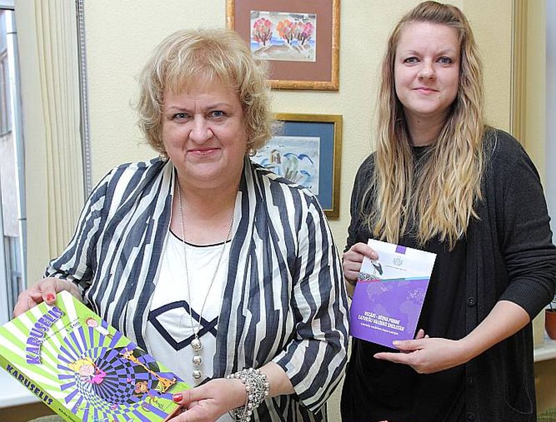 Latviešu valodas aģentūras direktora vietniece Dace Dalbiņa (no kreisās) un diasporas projektu koordinatore Aija Otomere rāda diasporas skoliņām sūtāmās grāmatas, kuru vidū ir arī “LA” apgādā izdotais Ulda Ausekļa dzejoļu krājums.