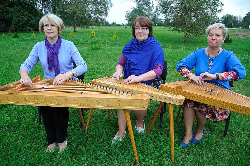 Trīs no piecām “Grobiņas” koklētājām” Robežnieku pļavā. No kreisās – ansambļa dalībniece Sandra Ostele, Robežnieku kultūras nama vadītāja Elga Jonase un vadītāja Agita Ēķe.
