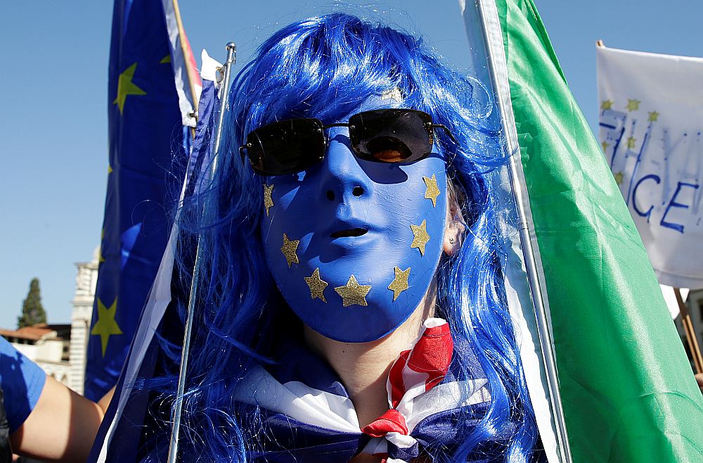 Demonstrants ES krāsu sejas maskā ar Britānijas un Itālijas karogiem pirms Apvienotās Karalistes premjerministres Terēzas Mejas runas Florencē atgādina, ka breksits grauj kā britu, tā eiropiešu cerības.