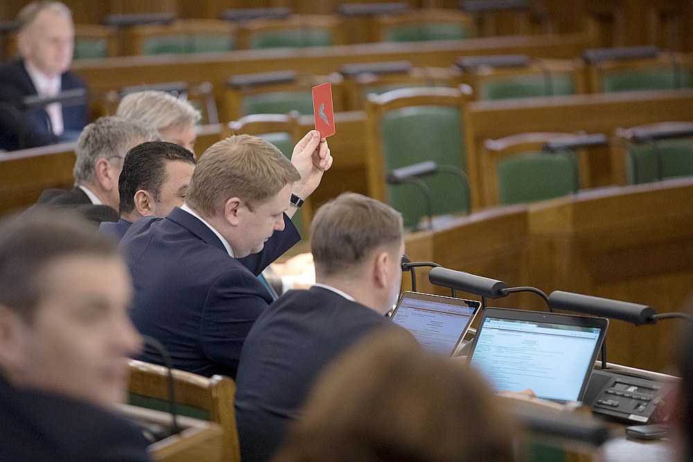 Edvards Smiltēns (ar paceltu balsošanas kartīti) pēc aiziešanas no “Vienotības” esot saņēmis atbalstītāju mudinājumus turpināt strādāt un pildīt pirms vēlēšanām dotos solījumus.