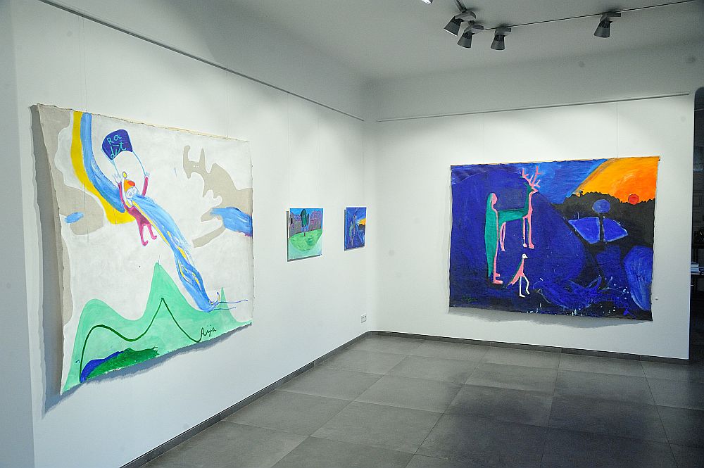 Skats no Aijas Zariņas izstādes “Tavs bērns II”. Priekšplānā pa kreisi – darbs “RA-dīt”. 2017. Audekls/eļļa, 151 x 195 cm. Pa labi – “Aust”. 2017. Audekls/eļļa, 172 x 221 cm.