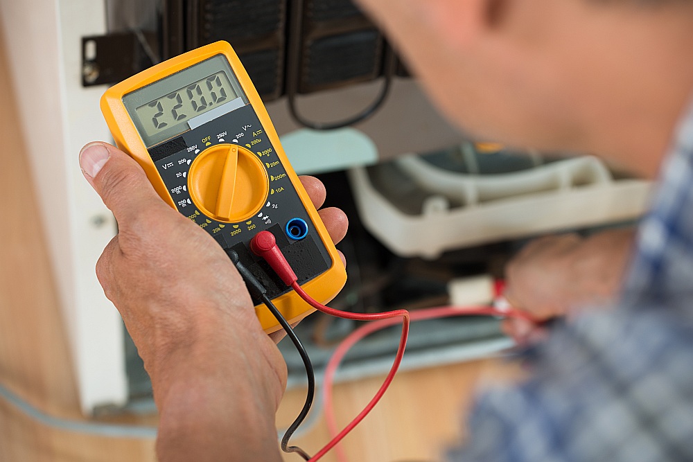 Elektriķis pārbauda spriegumu kontakligzdā.