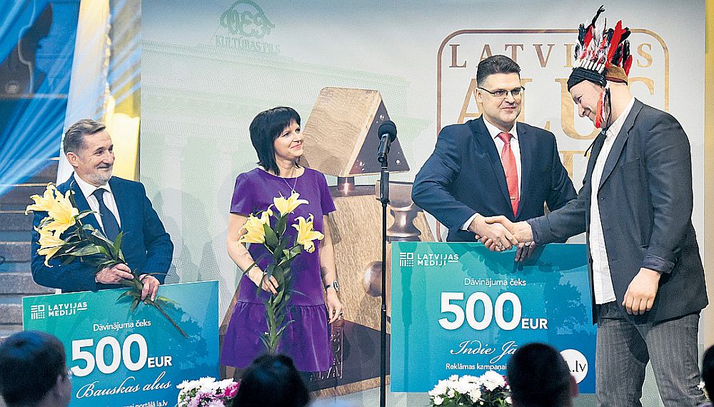 Zīmola “IndieJānis” brūvētājs Jānis Rudzītis (no labās) no AS “Latvijas Mediji” Reklāmas aģentūras direktora Aigara Stankēviča rokām saņem balvu par tautas mīlētākā alus zīmola titulu. “Bauskas alus” vadītājs Vladimirs Barskovs (no kreisās).