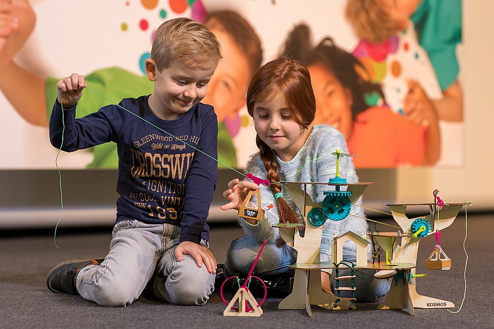 Bērni izstādē “Spielwarenmesse” aizrāvušies ar īpašu koka māju, kas skolēnu kategorijā atzīta par labāko rotaļlietu.