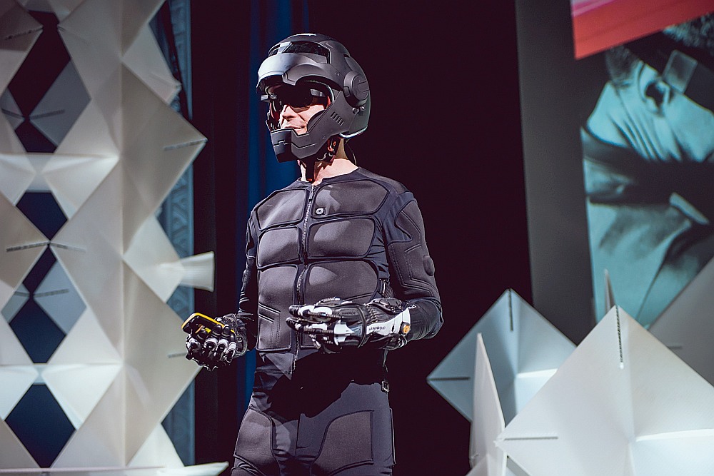 Dīns Džonsons tērpies t. s. “tesla suit” tērpā, kas strādā kā virtuālās realitātes papildinājums.
