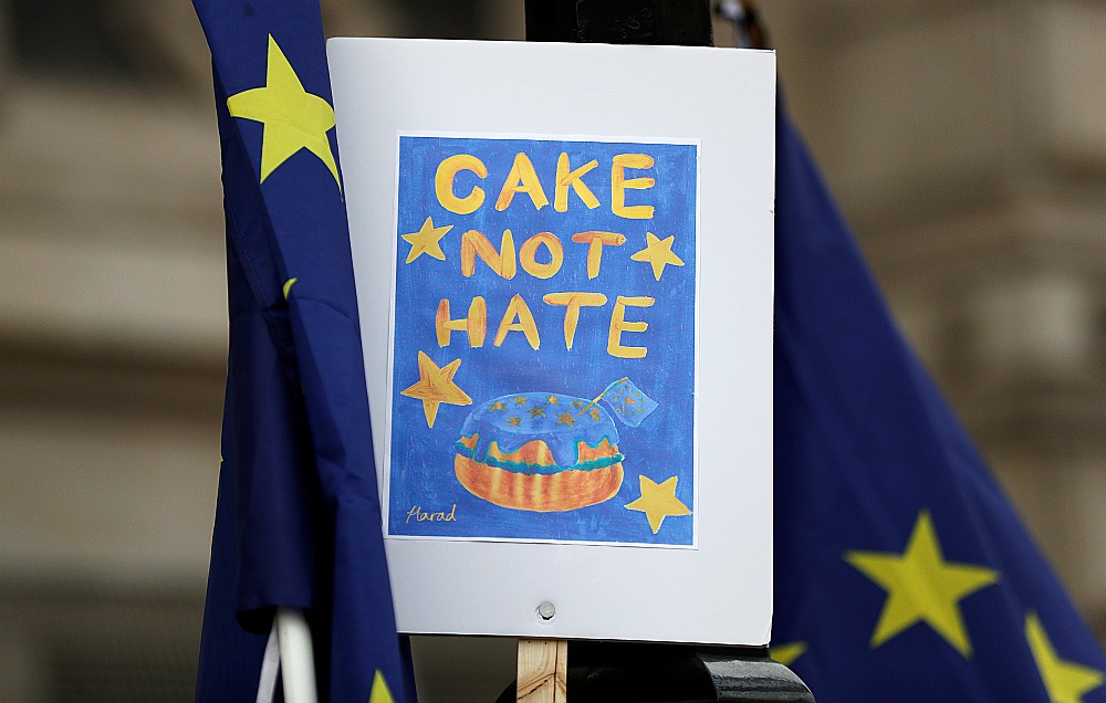 Protestētāji otrdien ar plakātu “Cake not hate” (vārdu spēle ar komatiem “Kūka ne naids”, pēc analoģijas ar “Sodīt nedrīkst apžēlot”) pie britu premjera rezidences.