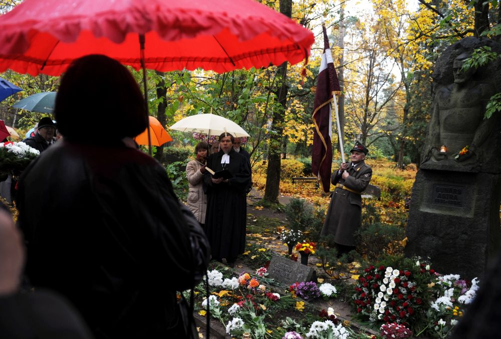 Mācītājs Guntis Kalme uzrunā klātesošos Meža kapos pie pretpadomju aktīvista Gunāra Astras atdusas vietas, kur notiek atceres brīdis. 2011. gada 22. oktobrī