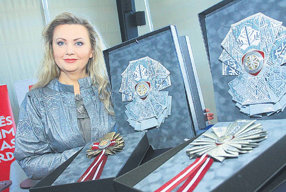 Lielās balvas dizaina, kā arī un virsvadītāju un virsdiriģentu Goda zīmes autore Evija Dāboliņa priecājas: “Balvu Dziesmu svētkiem darinu pirmoreiz un jūtos gandarīta par šādu iespēju.” Lielā balva veidota no zeltaini sudrabaina lina auduma ielocēm, kas izšūtas ar latvju rakstiem, kuru motīvi meklēti Jūlija Madernieka daiļradē. Vidū rotājas metāla goda zīme. Iedvesma ņemta no sprēslīcās, koklēs un pūralādēs iegrebtās saules zīmītes.
