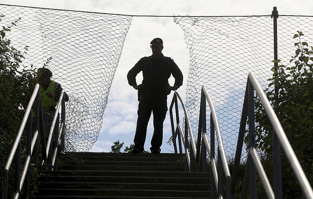 Austrijas policijas virsnieks robežapsardzības mācībās Špīlfeldā 26. jūnijā pie žoga uz Austrijas robežas ar Slovēniju.