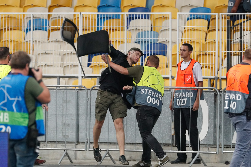 Kijevas “Dinamo” fans met krēslu pretinieku līdzjutēju virzienā.