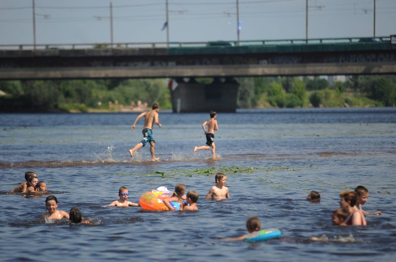 Cilvēki peldas peldvietā Lucavsalā.