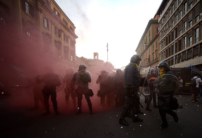 Anti-riot policemen stand in a street during clashes on the sidelines of an anti-austerity protest on October 19, 2013 in Rome. Tens of thousands of people took to the streets in Italy and Portugal on Saturday to protest against budget cuts and the social cost of the economic crisis, amid concern over possible claPhes in Rome. AFP PHOTO / FILIPPO MONTEFORTE