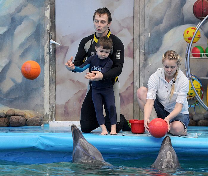A pedagogue-diver assists an autistic child during a dolphin therapy session at the cultural and health center Nemo in the Belarus capital Minsk, on December 3, 2012. AFP PHOTO / VIKTOR DRACHEV