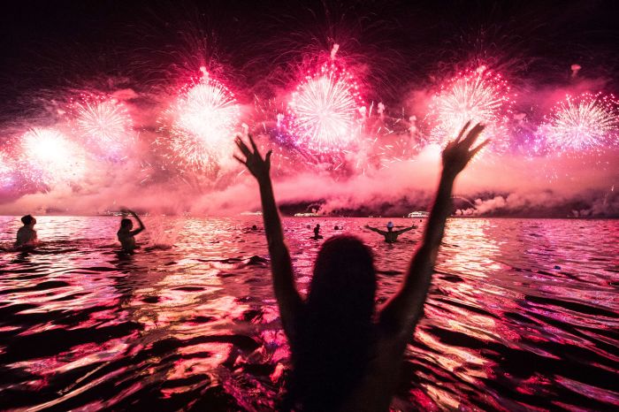 Cilvēki sajūsmā par Jaungada uguņošanu Riodežaneiro Kopakabana pludmalē 2014. gads AFP PHOTO / YASUYOSHI CHIBA
