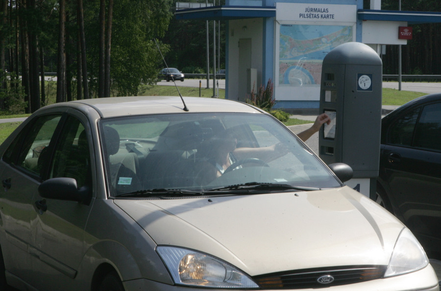 Sieviete iegādājas autotransporta caurlaidi iebraukšanai Jūrmalas pilsētas īpaša režīma zonā kontrolpunktā Priedainē pirms iebraukšanas pilsētā.