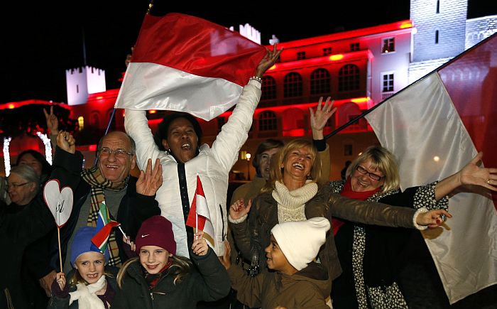 People celebrate in front of the Palace of Monaco as they celebrate the birth of baby twins to Prince Albert II and Princess Charlene of Monaco on December 10, 2014 in Monaco. Prince Albert II of Monaco and his wife Charlene welcomed their twin babies Gabriella and Jacques to the world, the palace announced. Prince Jacques is next in line to the throne. Gabriella Therese Marie was born at 5.04 pm followed by Jacques Honore Rainier two minutes later, the principality said in a statement, adding that both babies were “doing well”. AFP PHOTO / VALERY HACHE