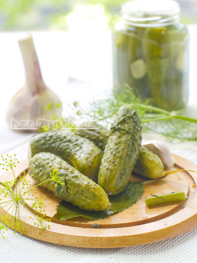 Hole fresh salted cucumber on plate with dills