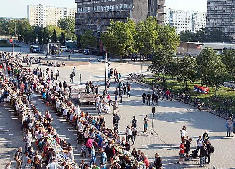 Dažās no paneļu mājām izmitināti arī patvēruma meklētāji, kas iedalīti saskaņā ar valsts iekšējo sadales mehānismu. Halles jaunpilsētas iedzīvotāji un patvēruma meklētāji pie kopgalda.