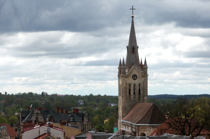 Skats uz Cēsu Svētā Jāņa evaņģēliski luteriskās baznīcas torni un namu jumtiem.