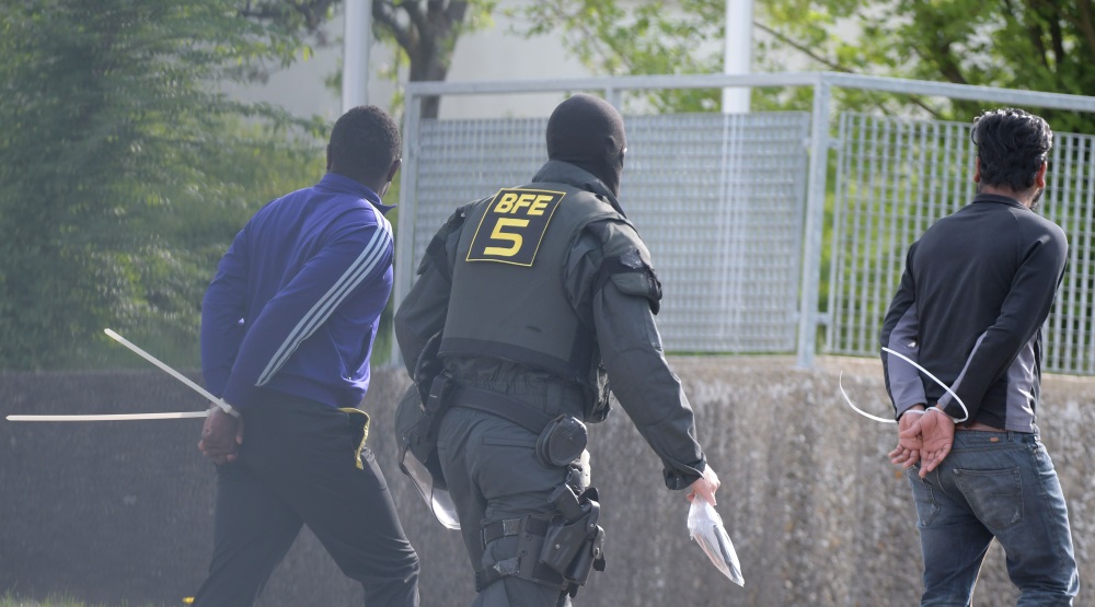 Bēgļu centrs Vācijā, kur bēgļi uzbrūk policijai un cenšas novērst kāda “savējā” deportēšanu uz Rietumāfiku, 03/.05.2018.