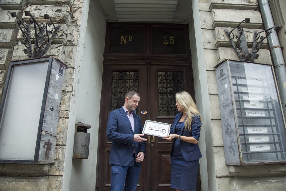 VAS “Valsts nekustamie īpašumi” valdes locekle Kitija Gruškevica simboliski nodod atslēgas būvniekam- pilnsabiedrības “RERE Būve 1” valdes priekšsēdētājam Valdiim Kokam.
