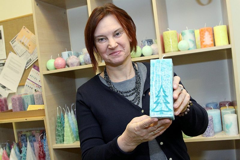 Inga Šķestere rāda biedrības darbnīcā tapušās skaistās sveces, kuras pirms Ziemassvētkiem dāvināšanai izvēlas daudzi.