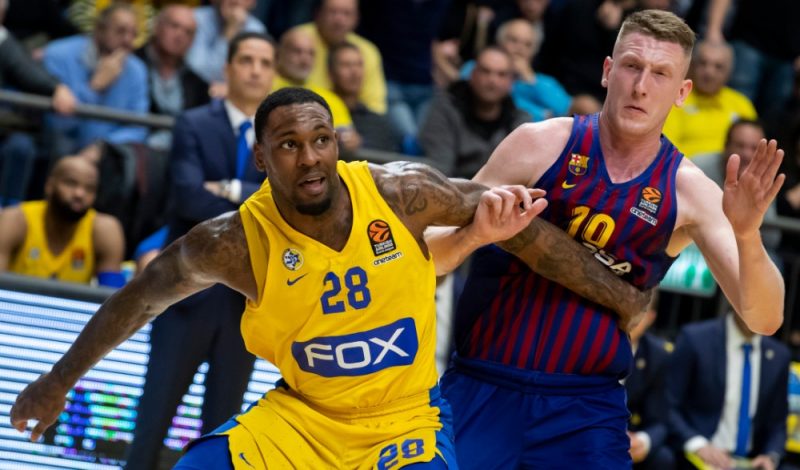 Rolands Šmits (no labās) pret “Maccabi Fox” spēlētāju Tariku Bleku.