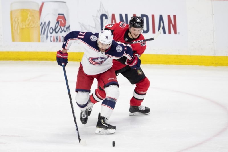 Rūdolfs Balcers (no labās) cenšas apturēt “Blue Jackets” spēlētāju Niku Folinjo.