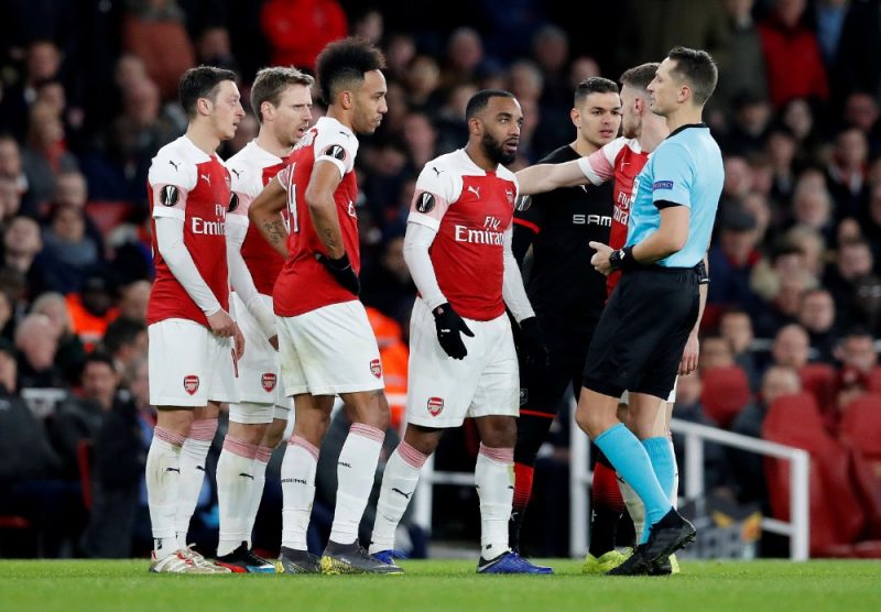 Londonas “Arsenal” kluba zvaigznes cenšas diskutēt ar latviešu tiesnesi Andri Treimani.