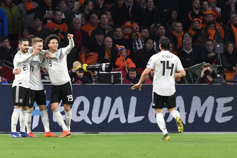 Vācijas futbola izlases spēlētāji priecājas par uzvaru.