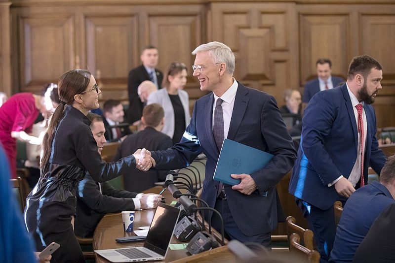 Premjers Krišjānis Kariņš Saeimas sēdē sacīja: “Latvija varētu būt pārtikusi ziemeļvalsts, kur cilvēki dzīvo drošībā, pārticībā – ir apmierināti ar dzīvi un laimīgi.” Attēlā: premjers sasveicinās ar Saeimas deputāti Karinu Sprūdi (“KPV LV”).