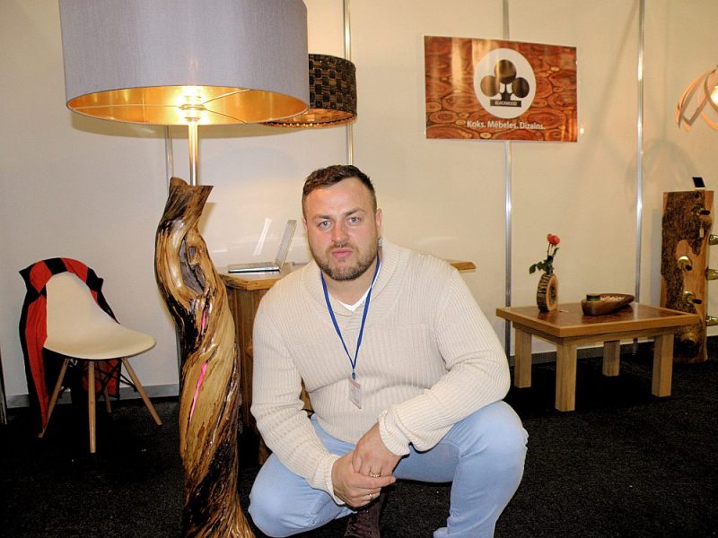 Dainis Sprudzāns ar koka stāvlampu, kas tapusi no tēva nozāģēta ceriņa stumbra.