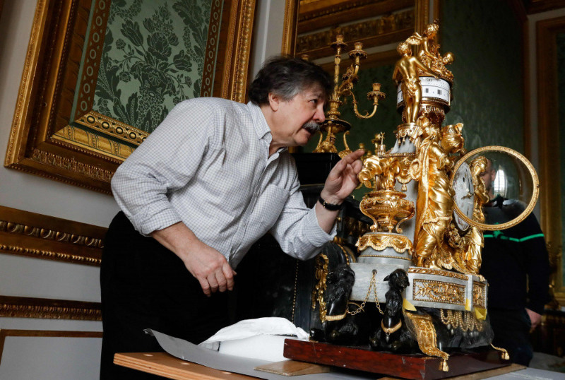 Versaļas pulksteņmeistars Bernārs Dro novieto Marijas Antuanetes guļamistabā “Sultānu pulksteni” – franču amatnieka Fransuā Remona (1747-1812) meistardarbu.