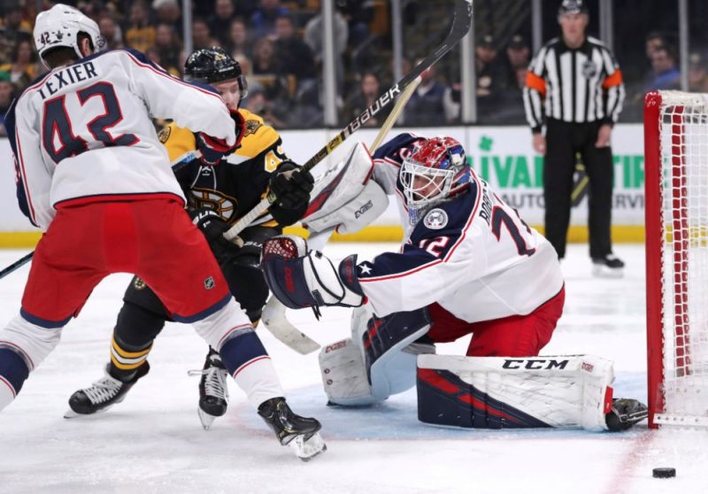 “Blue Jackets” pamatvārtsargs Sergejs Bobrovskis cīnās pret “Bruins” hokejistiem.